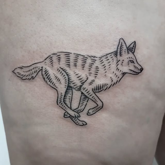 Black linework tattoo of a running fox